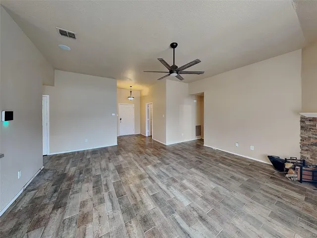 a view of a livingroom with a ceiling fan and wooden floor