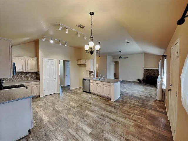 a kitchen with granite countertop a sink appliances and cabinets