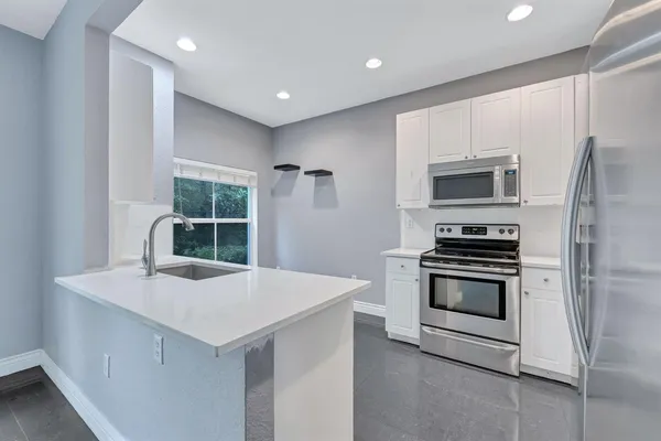 a view of a kitchen with a sink wooden floor and a window