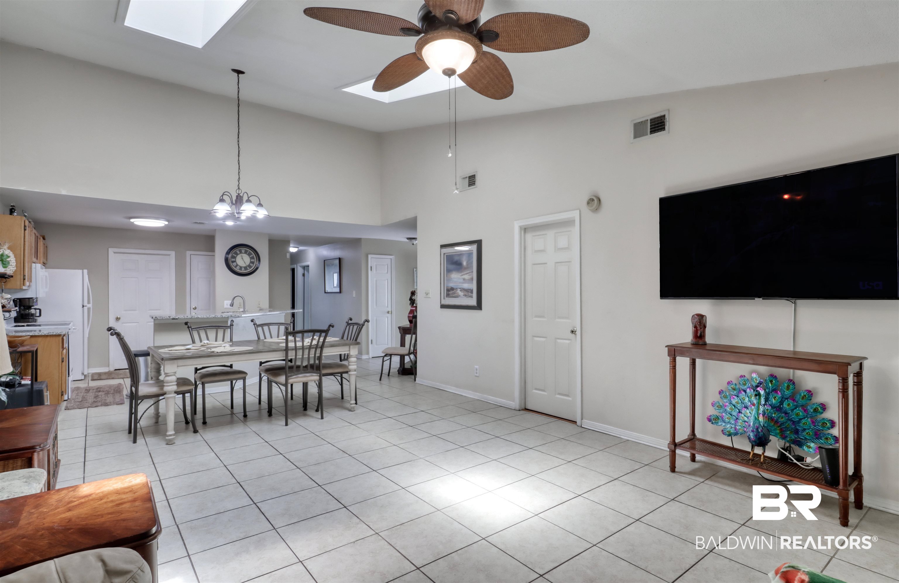 3200 Loop Road, Unit 61 Orange Beach, AL 36561 - Photo 8 of 32 Dining space featuring a skylight, a ceiling fan, high vaulted ceiling, light tile patterned flooring, and a chandelier
