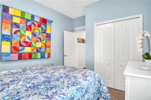 a bedroom with a bed and a lamp on dresser