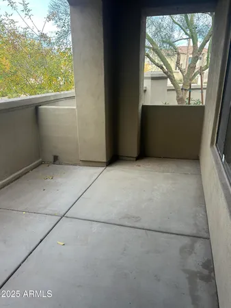 a view of a balcony with two plants and a yard