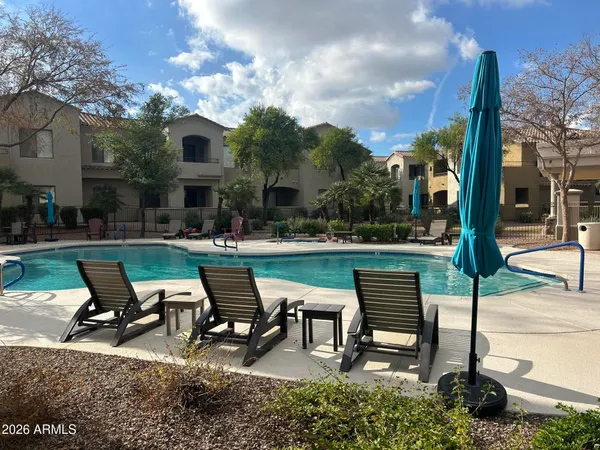 a view of a lake with table and chairs under an umbrella
