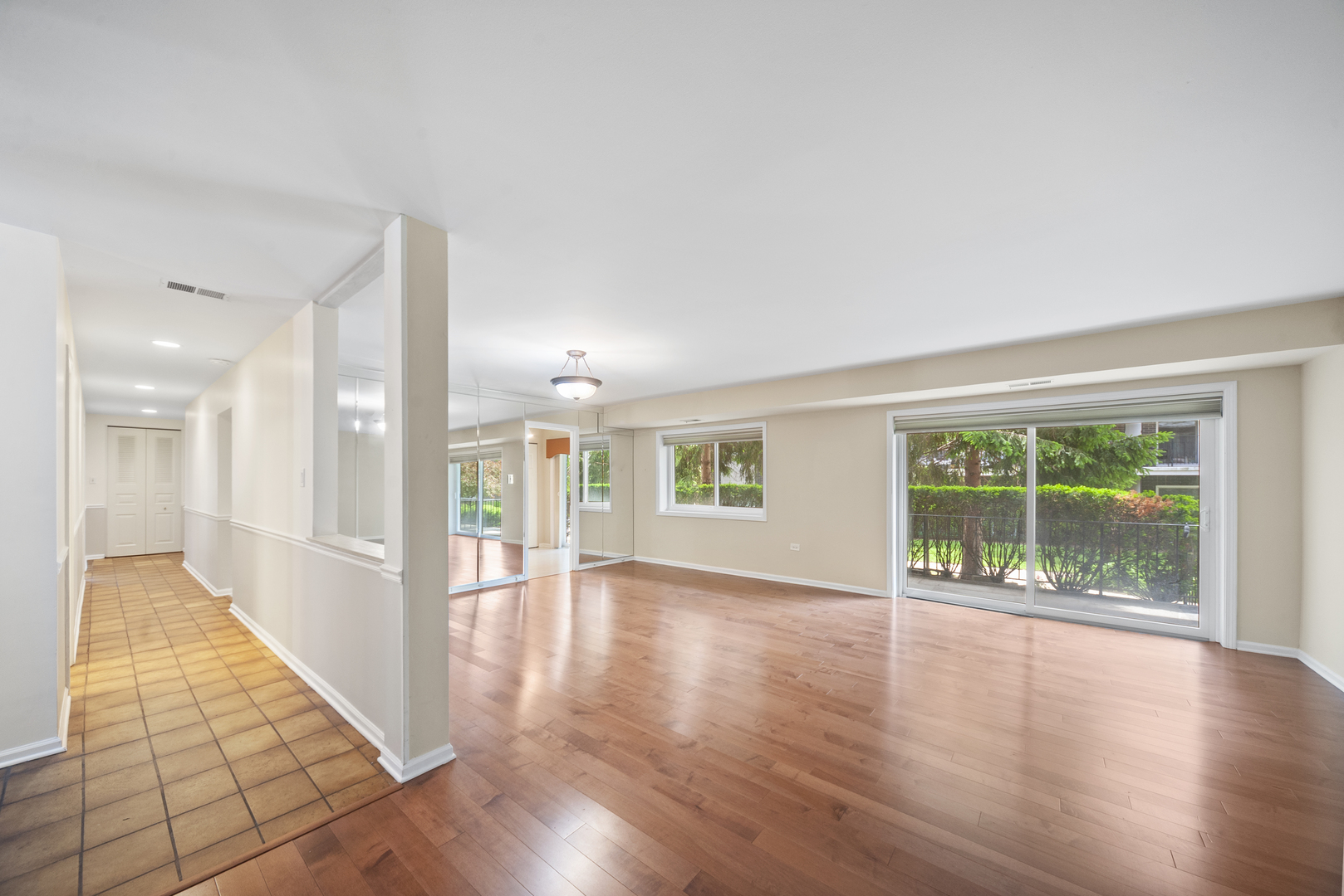 4949 Golf Road, Unit 101 Skokie, IL 60077 - Photo 6 of 22 an empty room with wooden floor and windows