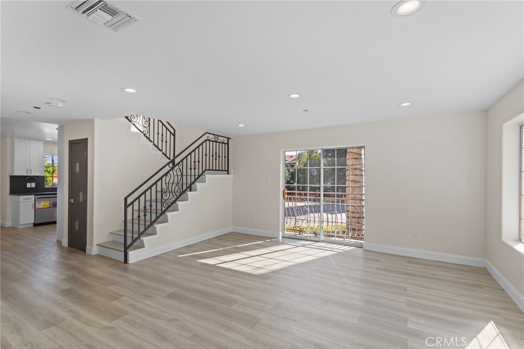 14957 Victory Boulevard, Unit 101 Van Nuys, CA 91411 - Photo 4 of 26 a view of an empty room with wooden floor and a window