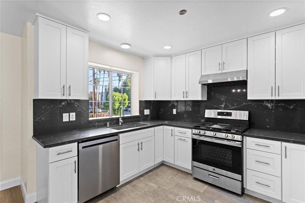 14957 Victory Boulevard, Unit 101 Van Nuys, CA 91411 - Photo 7 of 26 a kitchen with cabinets appliances a sink and a window