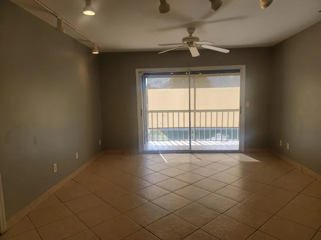 an empty room with windows and ceiling fan