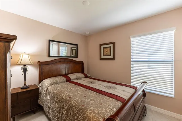 a bedroom with a bed chandelier and a window