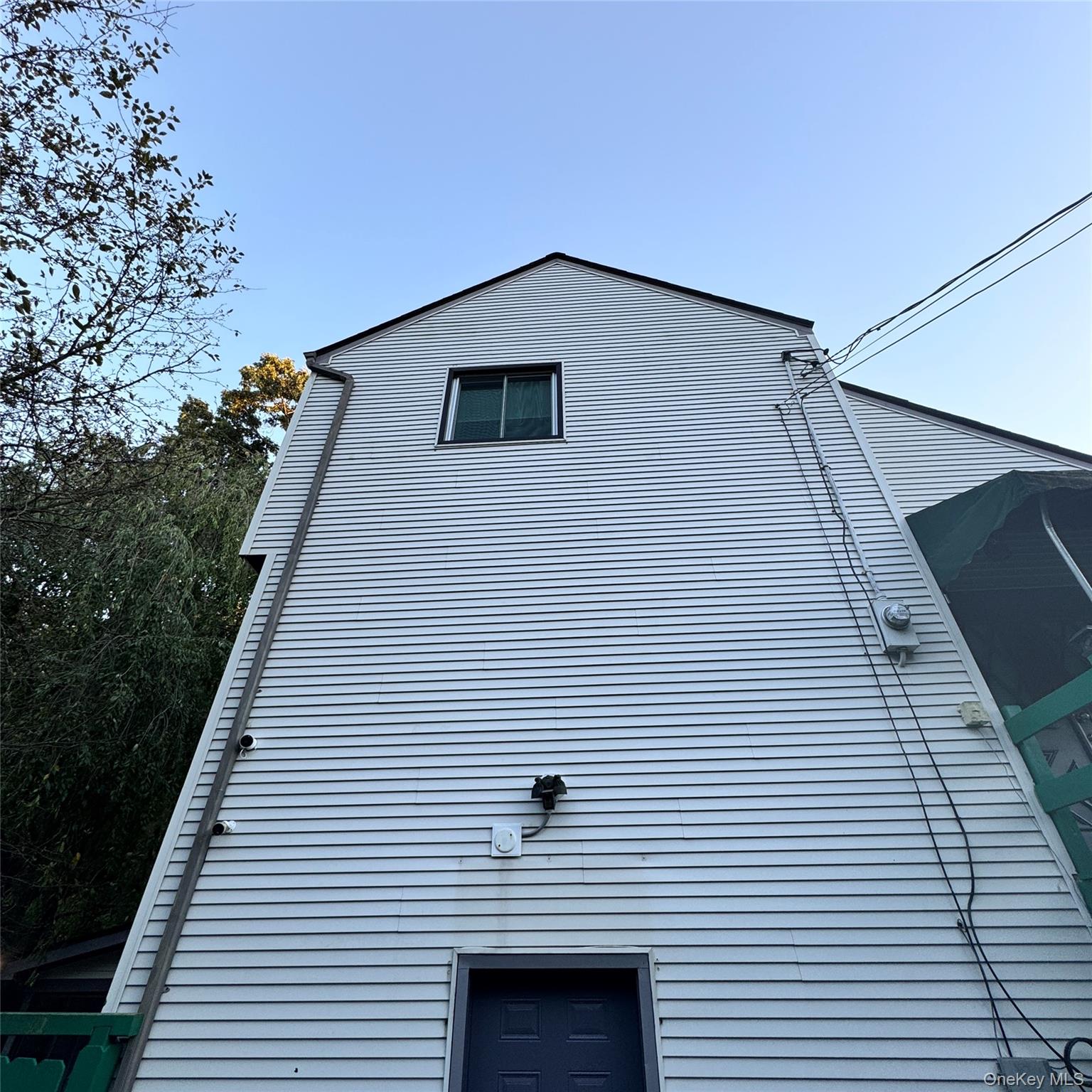 67 Steele Road New Windsor, NY 12553 - Photo 15 of 34 White horizontal siding exterior with a dark blue door and a single upper-level window
