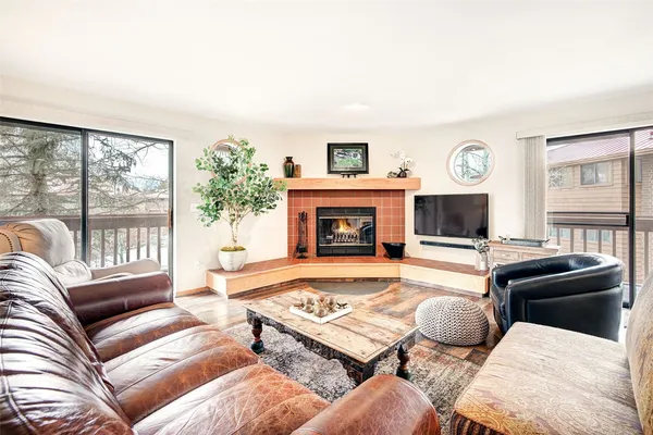 a living room with furniture large window and a fireplace