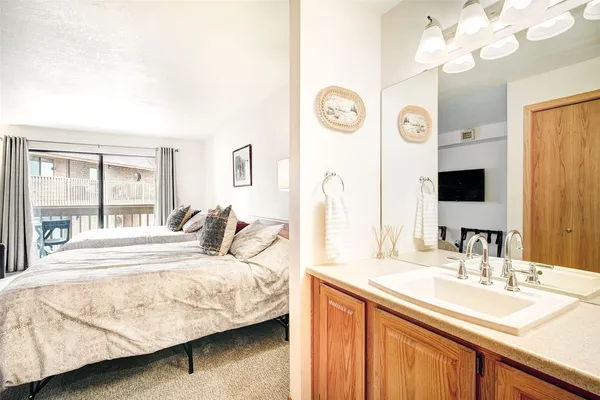 a bedroom with a bed and dresser with mirror