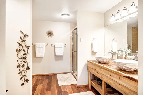 a bathroom with a granite countertop sink a mirror and shower