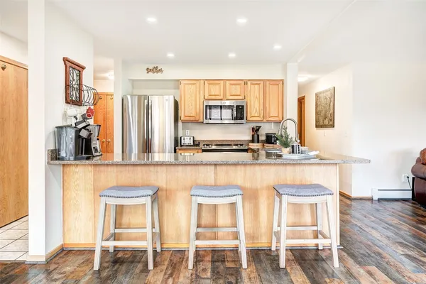 a kitchen with stainless steel appliances granite countertop a stove a sink and a refrigerator