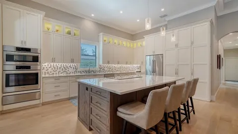 a kitchen with a table chairs sink and refrigerator