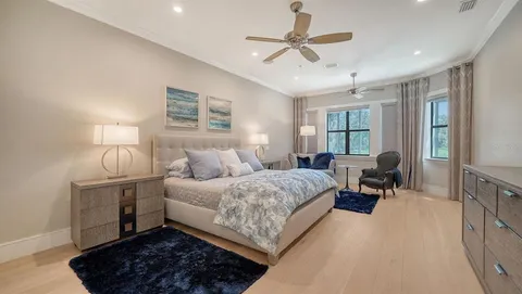 a spacious bedroom with a bed a couch and a chandelier