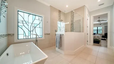 a bathroom with a tub a window and a shower