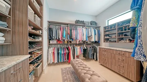 a view of walk in closet with clothes and shoes