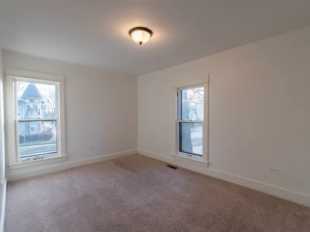 an empty room with windows and closet