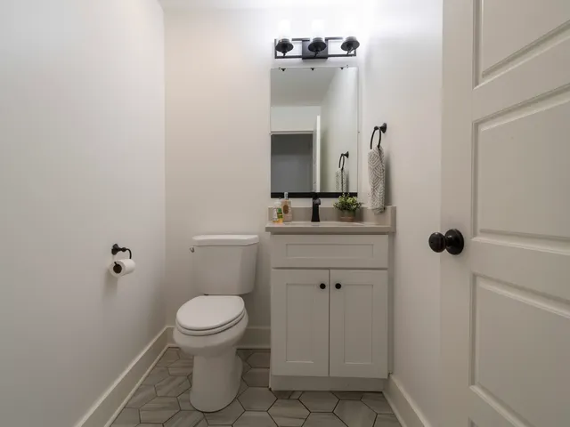 a bathroom with a granite countertop sink toilet and mirror