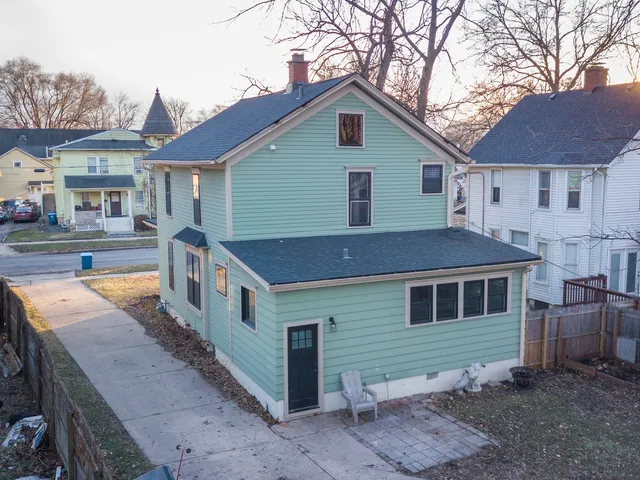 a front view of a house with large yard and a large tree