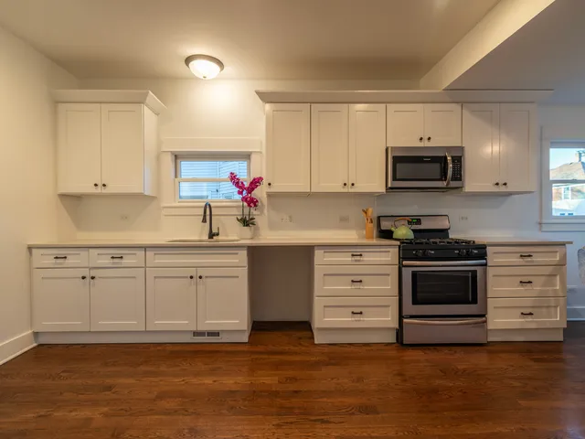 a kitchen with appliances a sink and cabinets