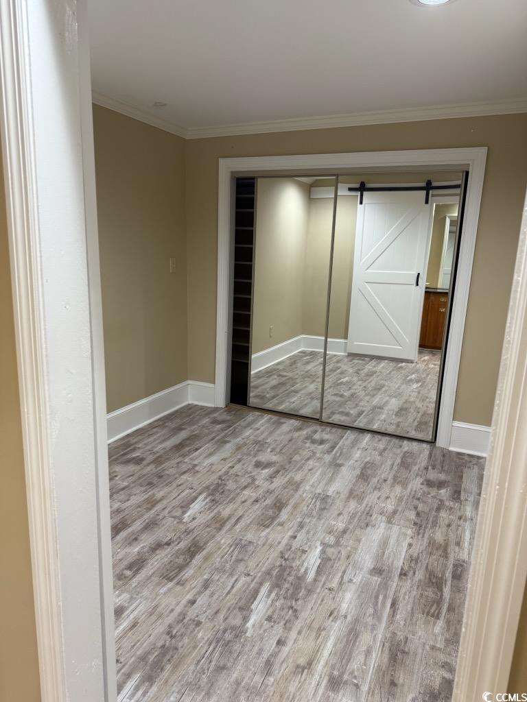 801 Front Street, Unit APARTMENT C Georgetown, SC 29440 - Photo 7 of 8 Unfurnished bedroom with a barn door, light wood-s