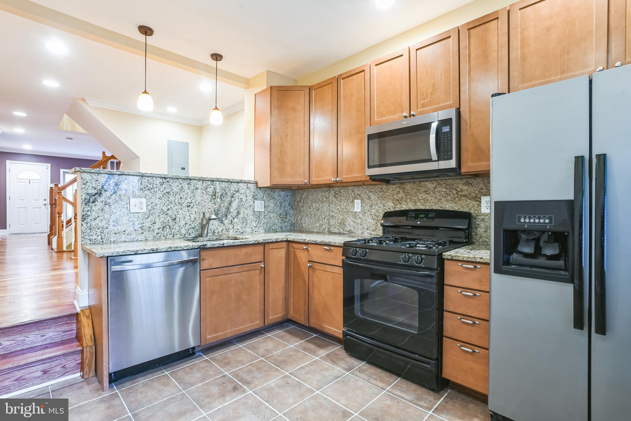 129 North Duncan Street Baltimore, MD 21231 - Photo 12 of 34 a kitchen with stainless steel appliances granite countertop a stove a sink and a refrigerator