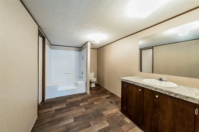 a bathroom with a granite countertop sink mirror and shower