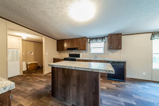 a view of kitchen with stainless steel appliances granite countertop refrigerator sink and stove