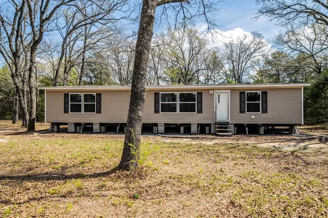 a view of a house with a yard covered in snow
