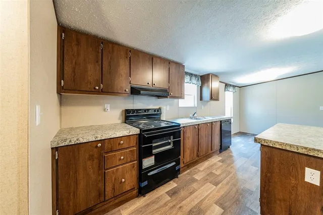 a kitchen with stainless steel appliances granite countertop wooden cabinets stove top oven and sink