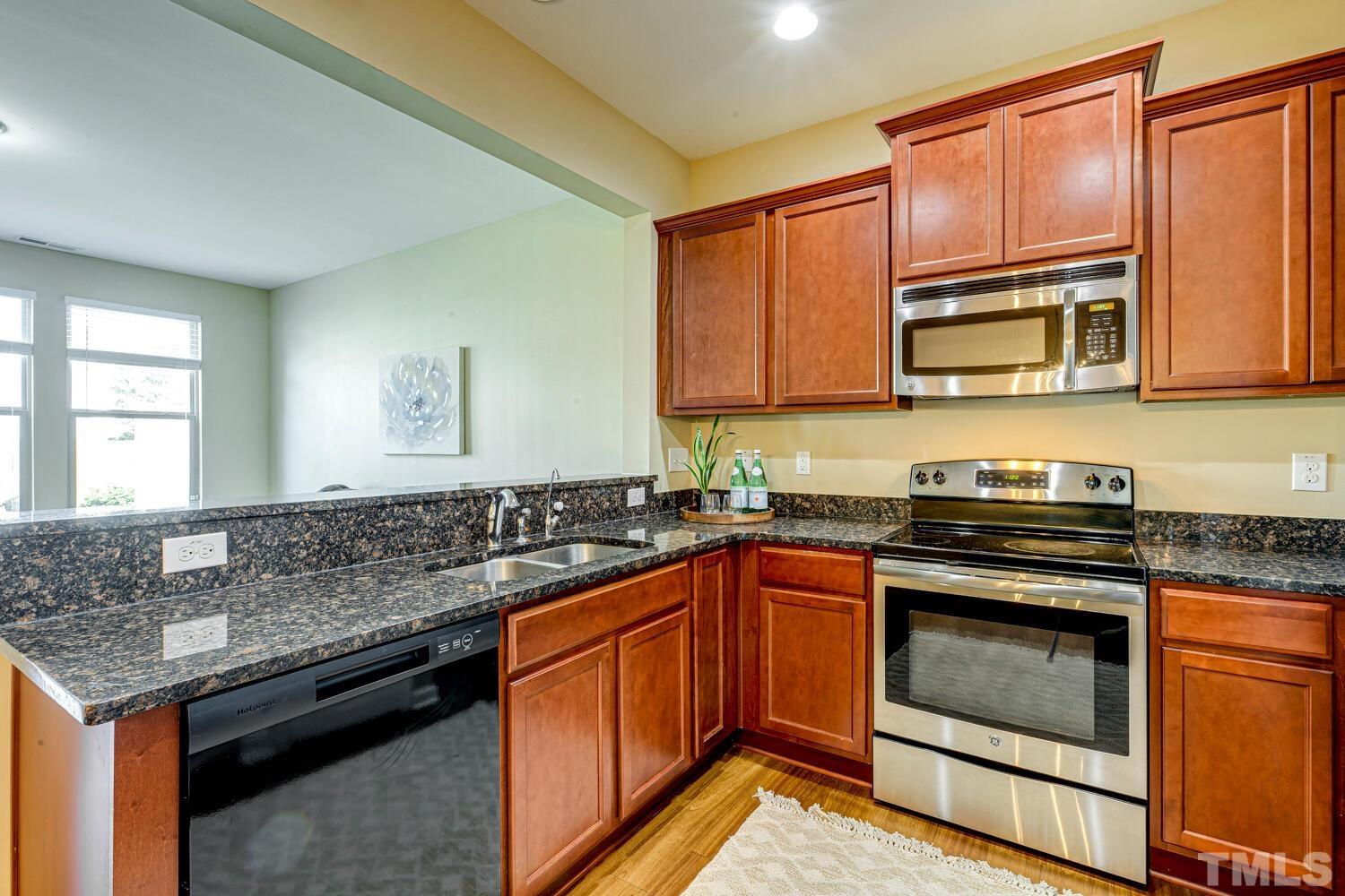 2416 Savior Street Raleigh, NC 27610 - Photo 14 of 47 a kitchen with granite countertop stainless steel appliances a stove sink and microwave