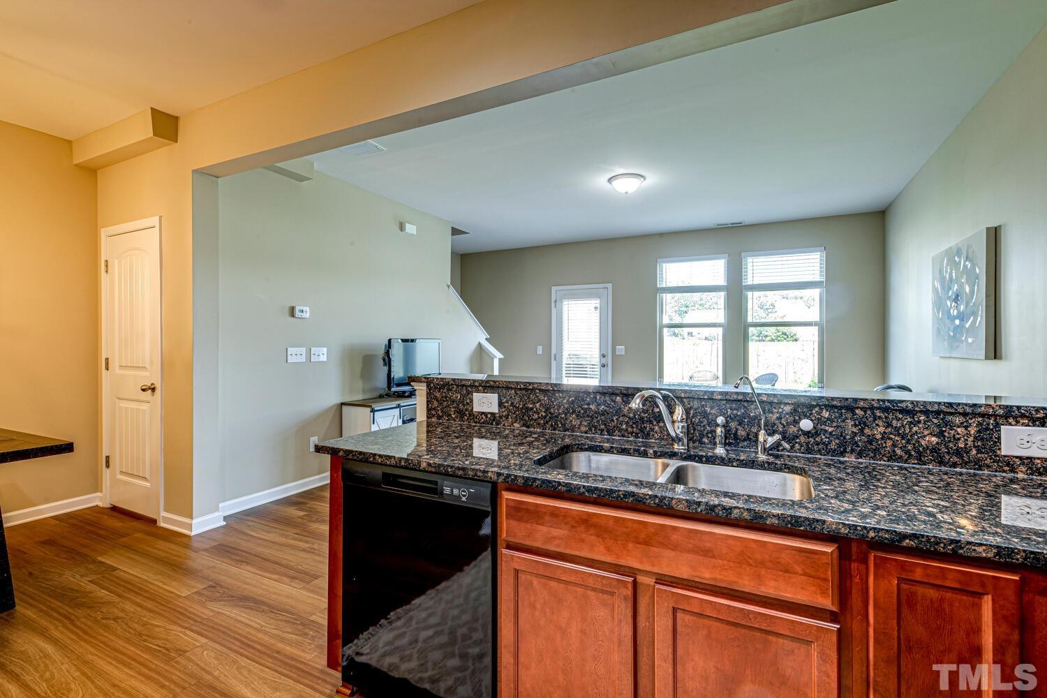 2416 Savior Street Raleigh, NC 27610 - Photo 17 of 47 a kitchen with granite countertop a sink and a wooden floor