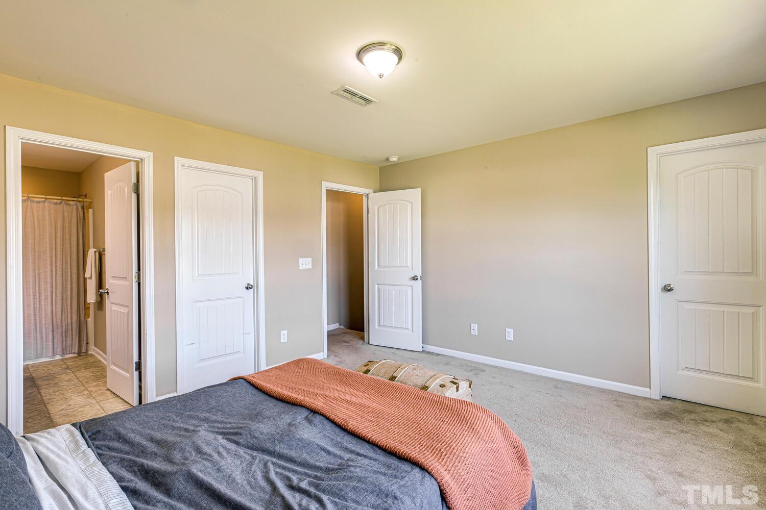 2416 Savior Street Raleigh, NC 27610 - Photo 24 of 47 a bedroom with a bed and a chandelier
