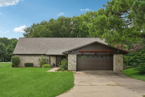 a front view of a house with a garden and yard