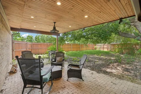 a view of a patio with table and chairs and floor to ceiling window