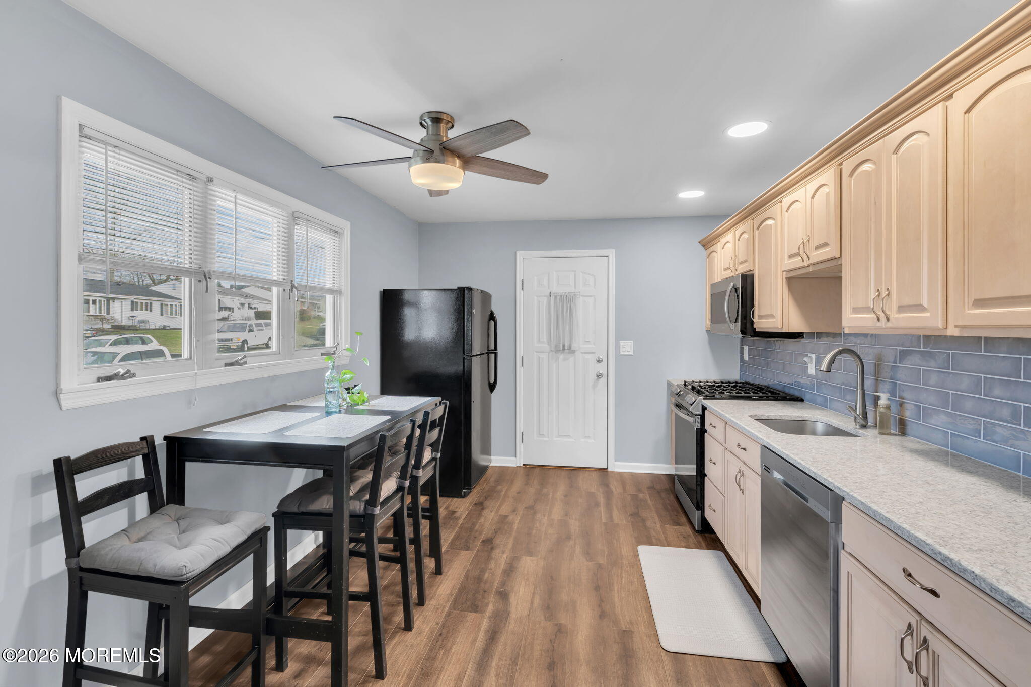 16 Hemlock Drive Parlin, NJ 08859 - Photo 8 of 22 a kitchen with stainless steel appliances granite countertop a stove a refrigerator a sink dishwasher a dining table and chairs with wooden floor