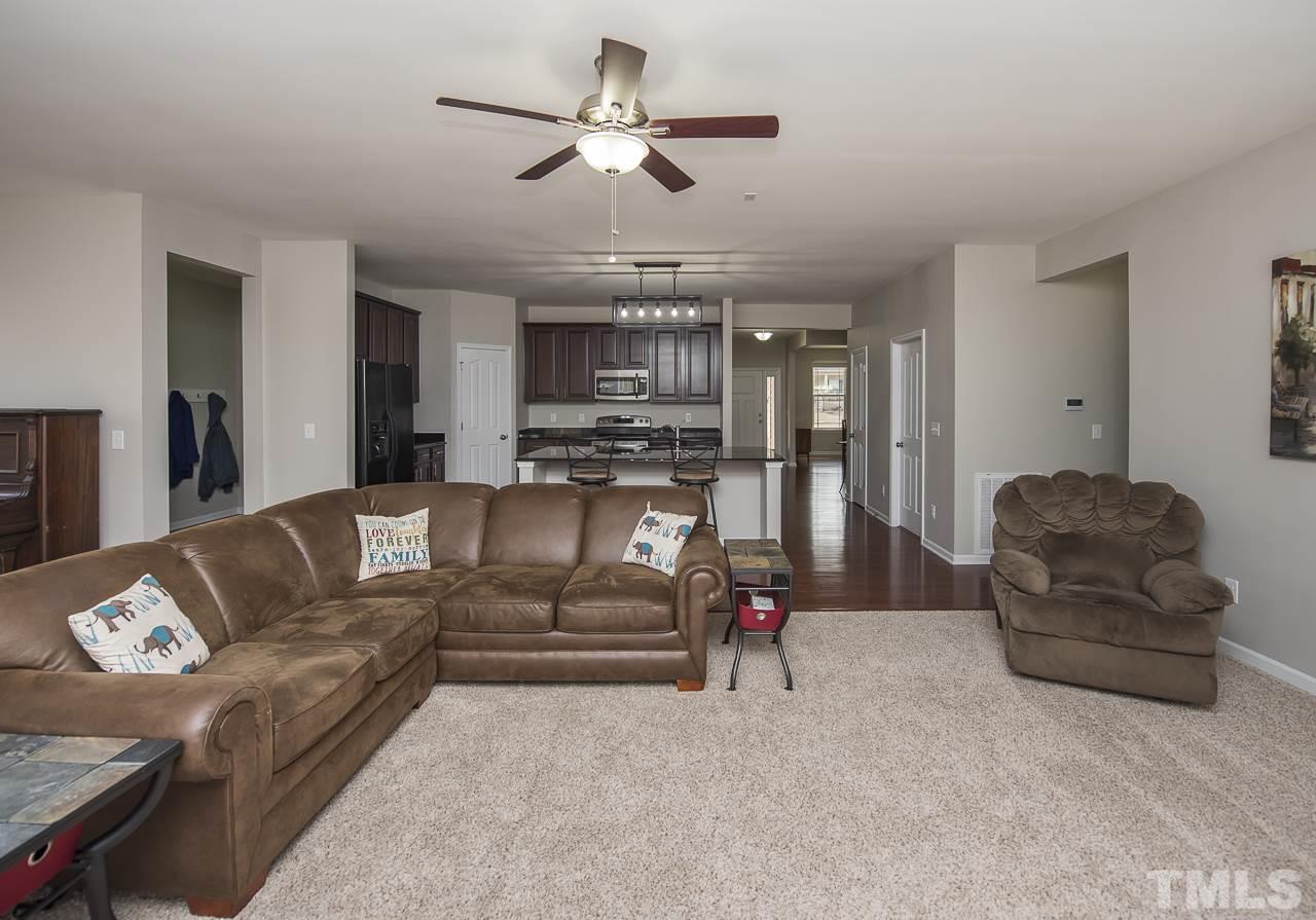 1136 Farmers Branch Road Willow Spring, NC 27592 - Photo 12 of 30 a living room with furniture kitchen view and a chandelier
