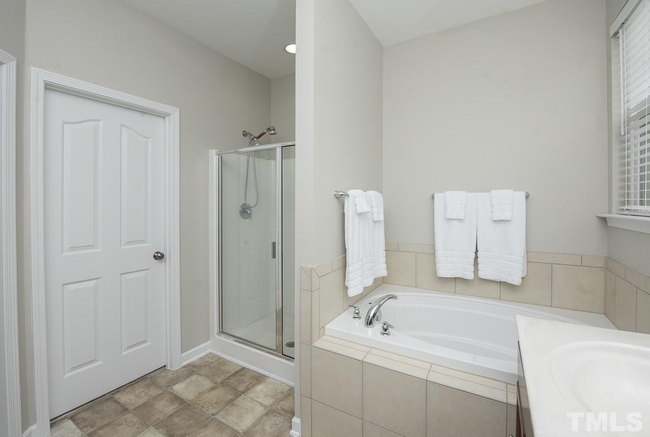 1136 Farmers Branch Road Willow Spring, NC 27592 - Photo 17 of 30 a spacious bathroom with a sink a mirror and a bathtub