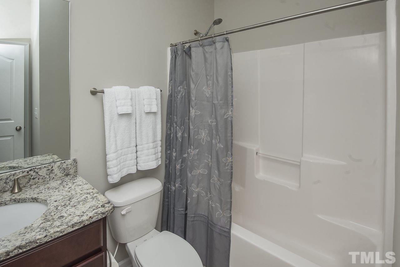 1136 Farmers Branch Road Willow Spring, NC 27592 - Photo 21 of 30 a bathroom with a granite countertop sink toilet and shower