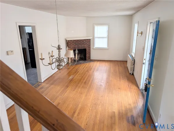 a view of a livingroom with wooden floor and a fireplace
