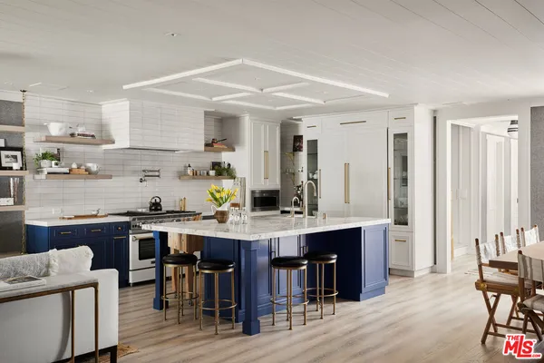 a large kitchen with cabinets table and chairs