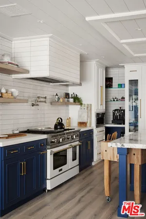 a kitchen with stainless steel appliances a stove a sink wooden floor and cabinets