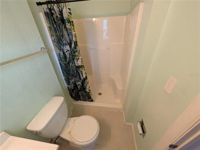 a white toilet sitting next to a shower curtain