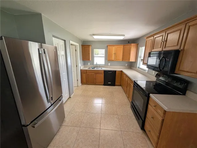 a large kitchen with a stove a refrigerator and a sink