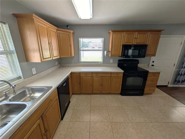 a large kitchen with a stove a sink and a microwave