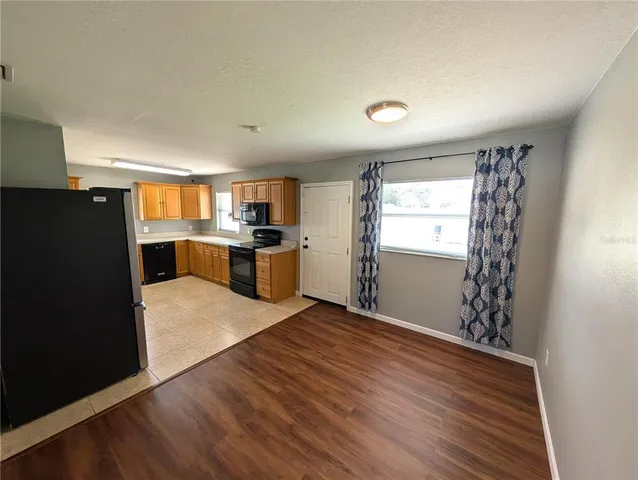 a kitchen with granite countertop a refrigerator and a stove top oven