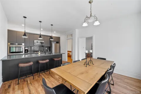 a kitchen with a table chairs and wooden floor