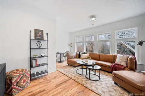 a living room with furniture a rug and wall paintings