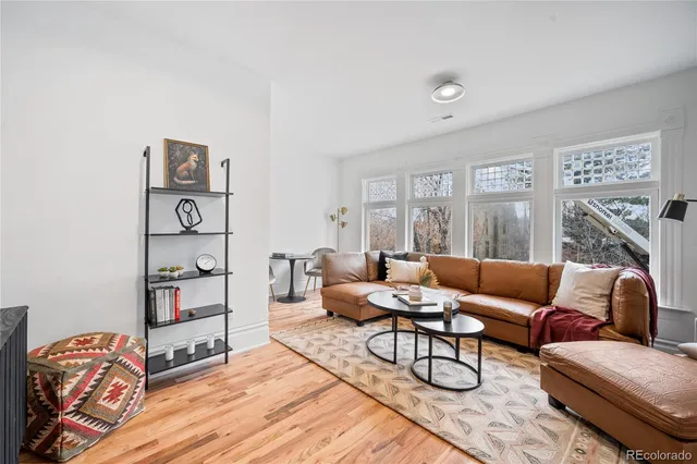 a living room with furniture a rug and wall paintings